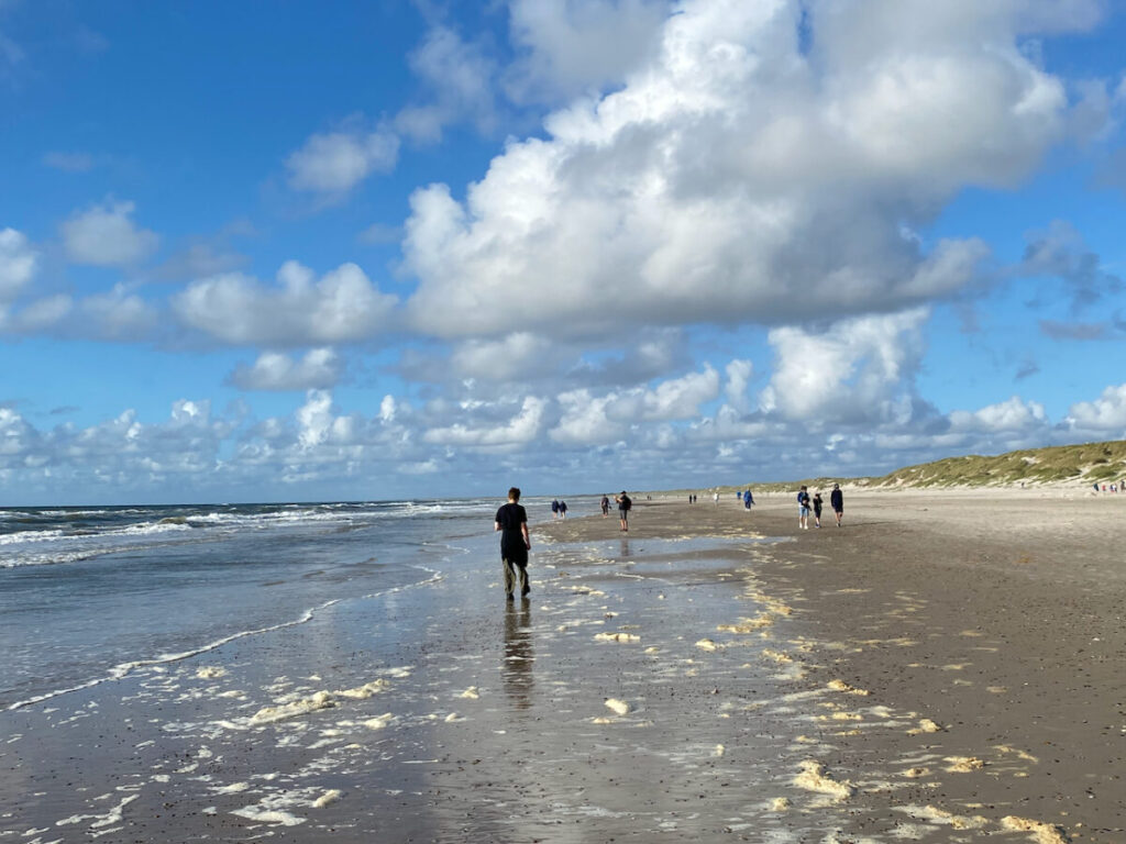 Jütland, Hvide Sande: Sonne, Wolken, spiegelnder Wassersaum mit Strandspaziergängern
